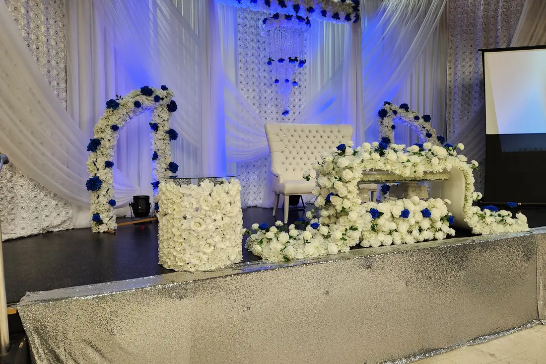 Silver sequin wedding stage with a sculptural white and navy floral installation and a beaded crystal backdrop